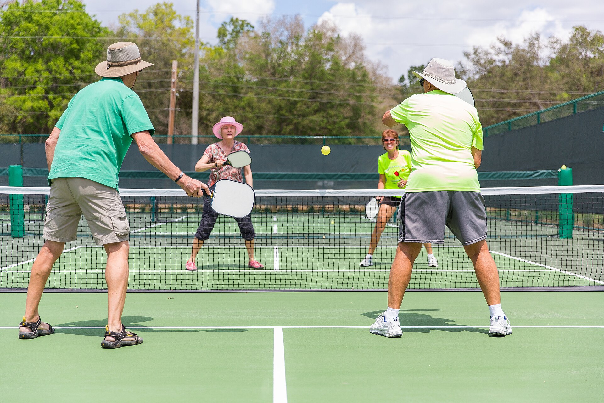 A group playing pickleball on an outdoor court